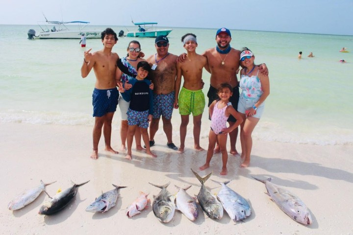 a group of people standing on top of a sandy beach